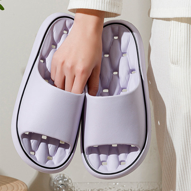 White open-toe slide slippers with molded cushioned footbed and dark trim edging.