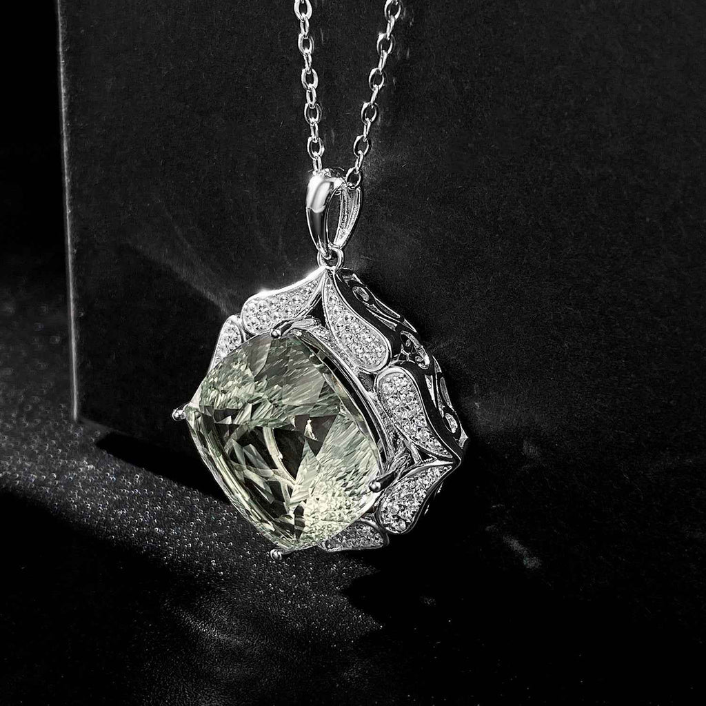 Large green crystal pendant necklace with silver-toned leaf design and bezel setting