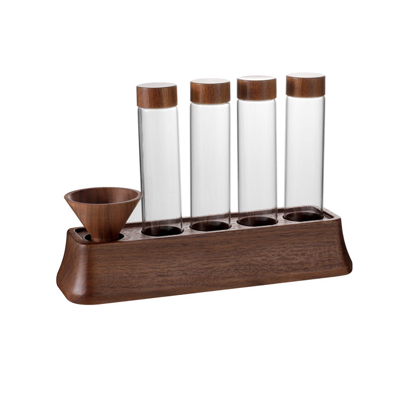 Clear glass tubes with cork lids in a wooden coffee bean display stand with a funnel cup