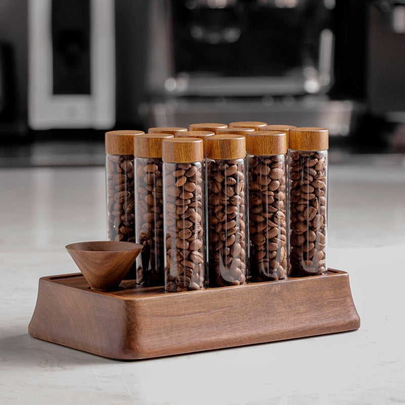 Clear glass coffee storage tubes with cork lids, arranged on a wooden display stand