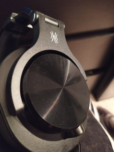 Black over-ear headphone earcup with textured speaker grille and control panel