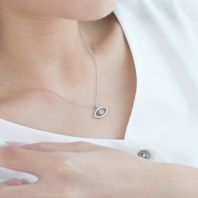 Sterling silver evil eye pendant necklace worn close-up, blue center with bright bezel