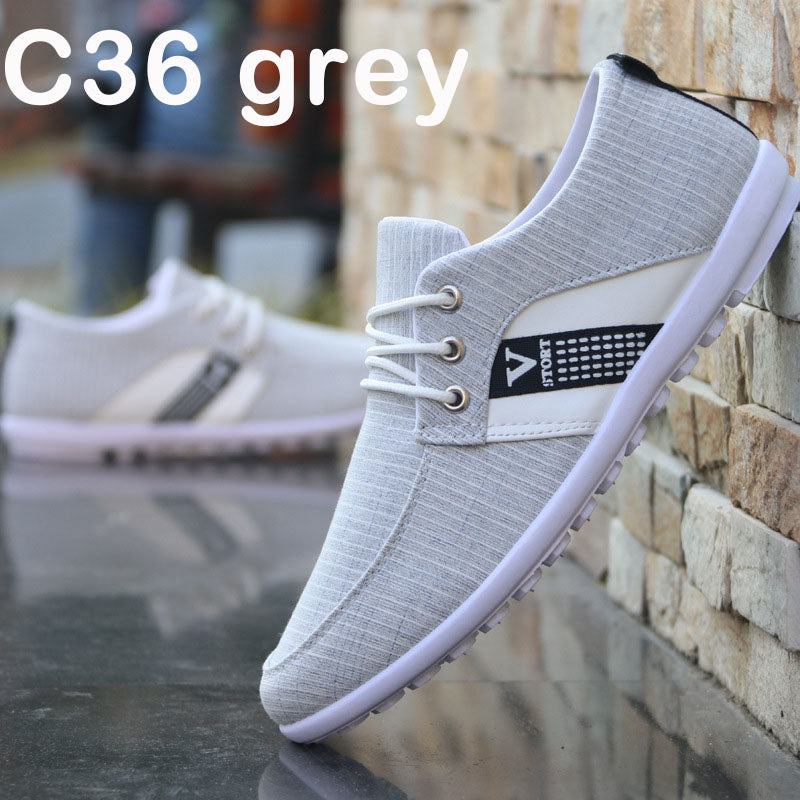 Grey canvas lace-up shoe with black side label and red-blue stripe, white sole