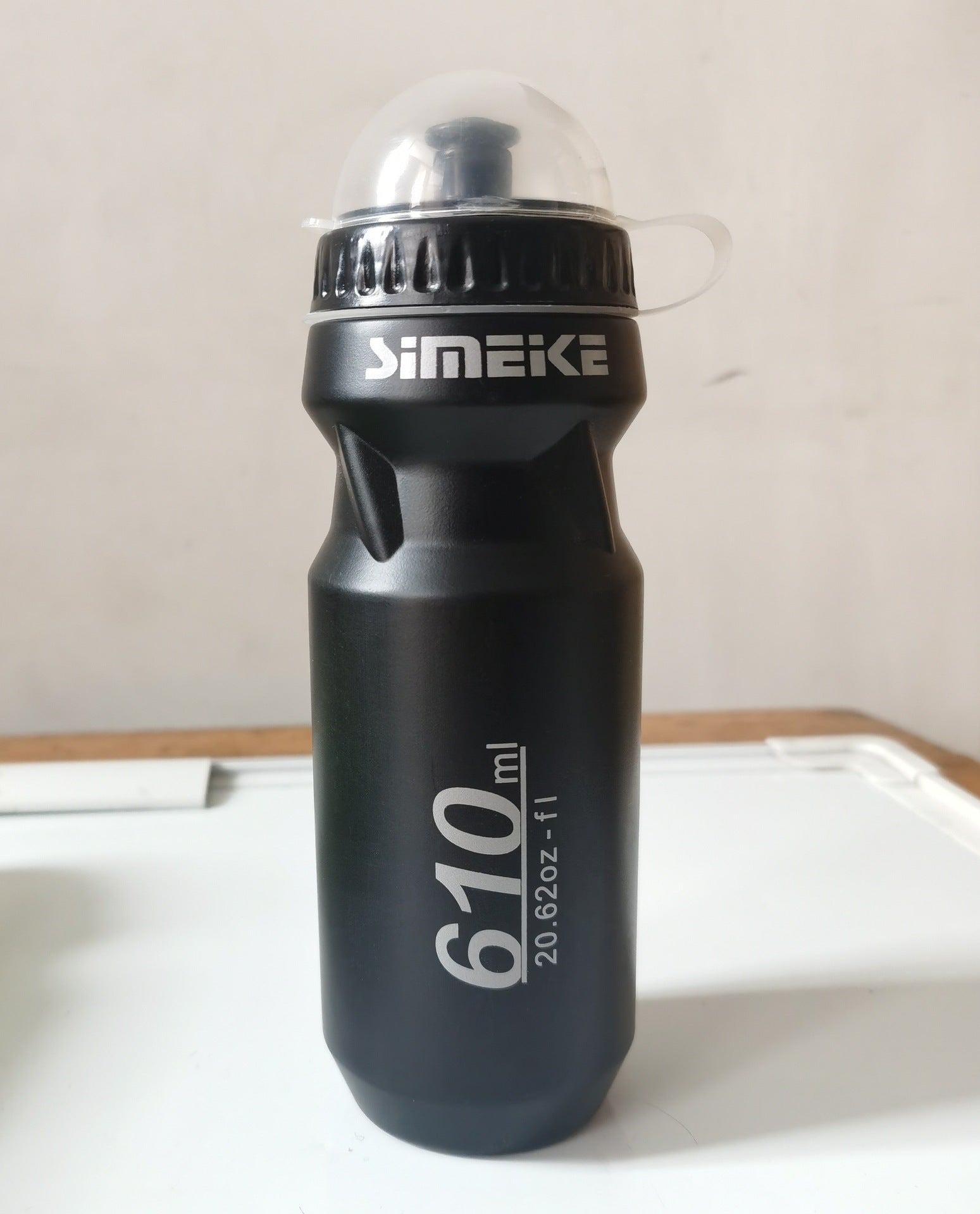 Black bicycle water bottle with 610 ml marking and flip top.