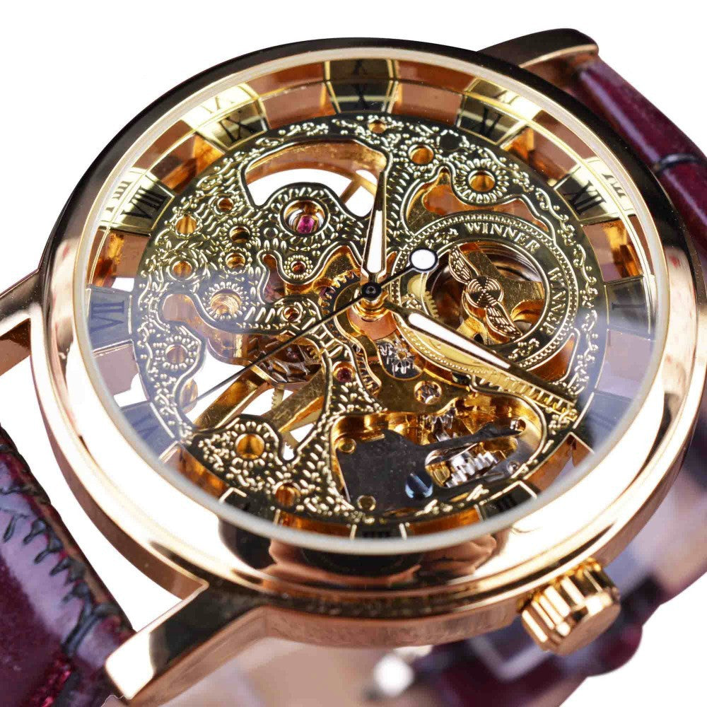 Mechanical watch with gold-tone openwork dial, amber accents, and brown leather strap