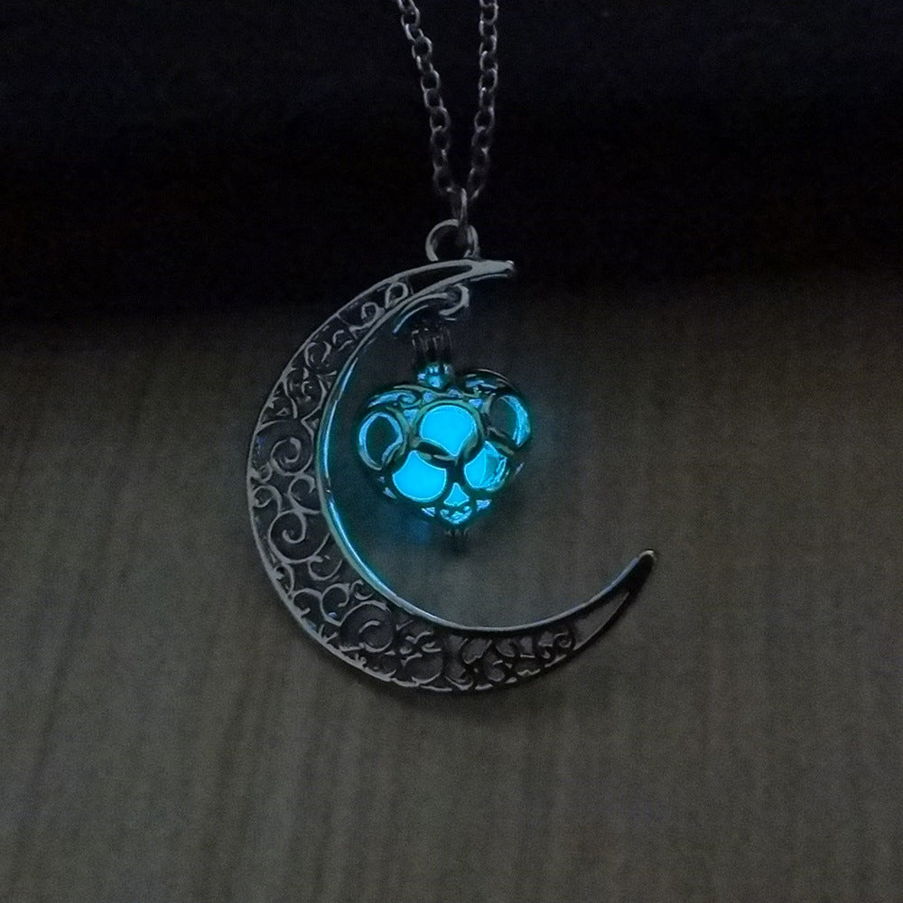 Close-up silver moon pendant with glowing blue cat charm on chain
