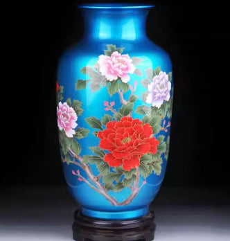 Ceramic vase in bright blue with pink and white blossoms, glossy base.