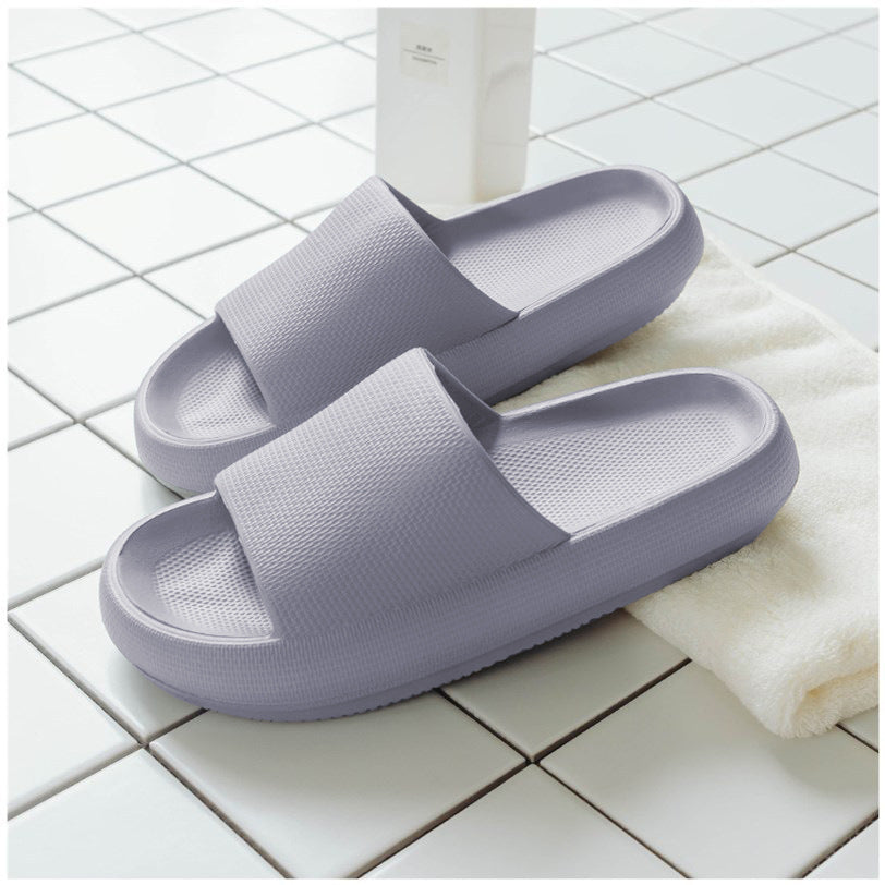 Light gray slide slippers with wide textured straps and cushioned sole