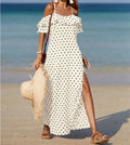 Off-shoulder long polka dot dress in white with black dots, ruffled sleeves and side slit
