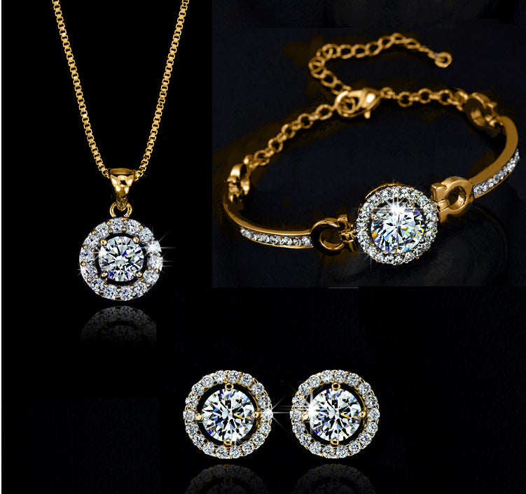 Gold jewelry set with round pendant necklace, bracelet with round centerpiece, and studs