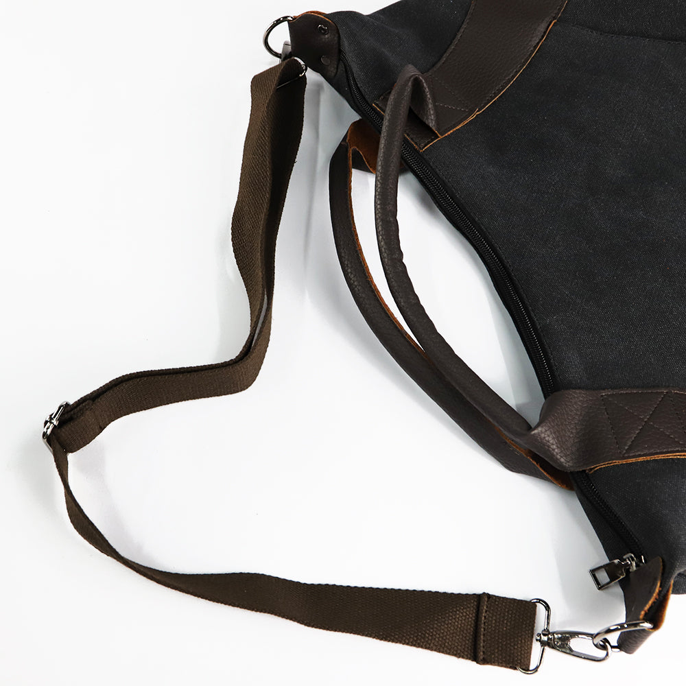 Dark canvas shoulder bag with adjustable crossbody strap and zipper pocket hardware