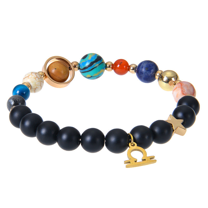 Zodiac beaded bracelet with black matte beads, colorful planet stones, and gold charm accents