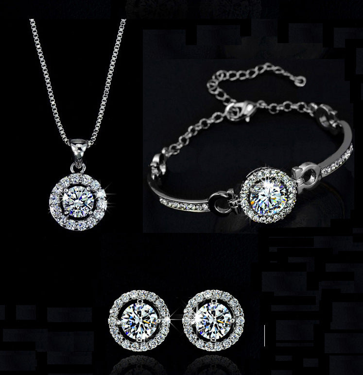Silver jewelry set with round pendant necklace, matching bracelet and stud earrings