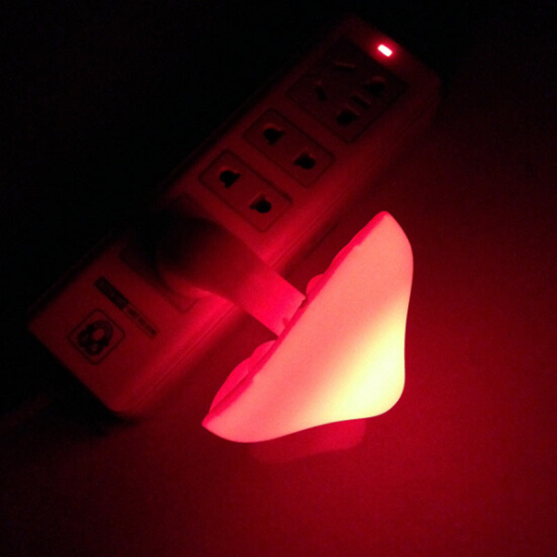 Plug-in mushroom LED night light glowing red from wall outlet