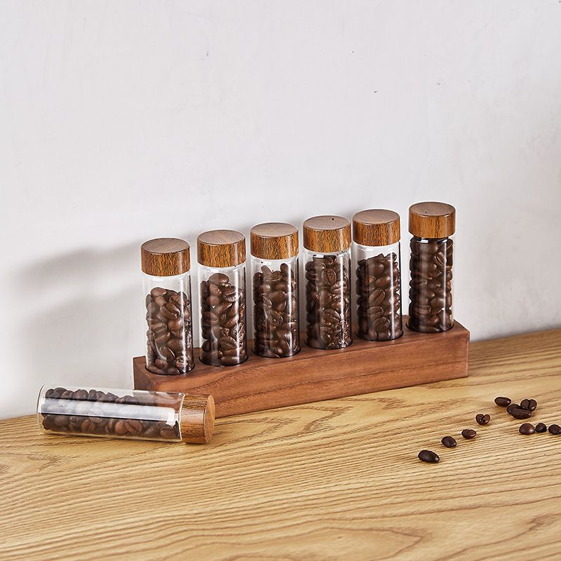 Wooden bean bottle display rack with clear glass bottles, wooden caps, and loose beans