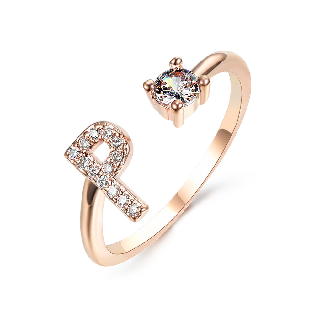 Rose gold adjustable initial ring with one-loop letter shape and round center stone.