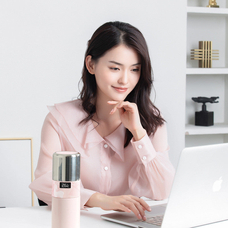Pink vacuum temperature bottle on desk, 26°C display near laptop