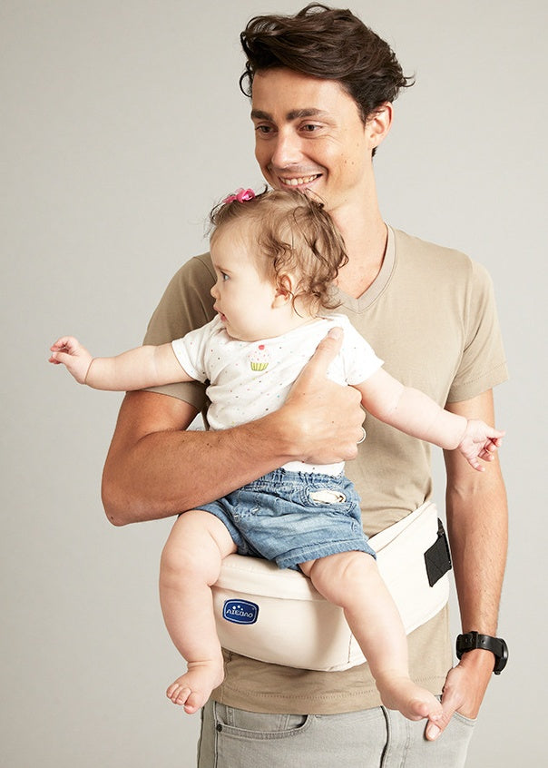 Cream baby sitting stool worn on front with mesh side panel