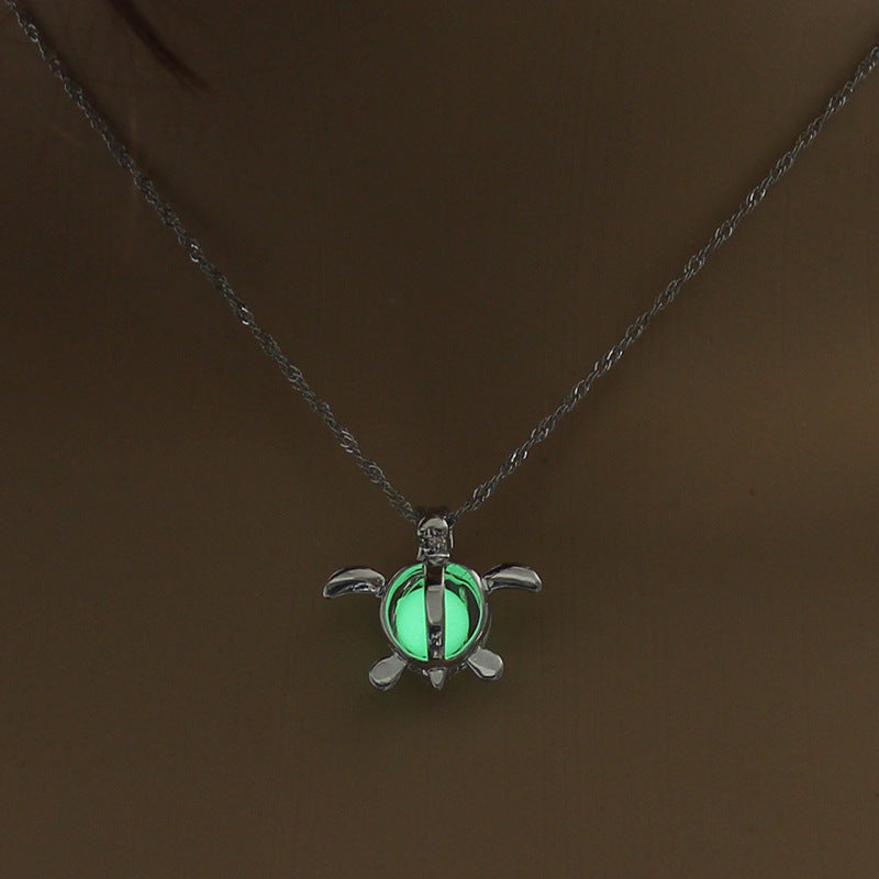 Silver lotus-like pendant necklace with glowing green stone on a chain