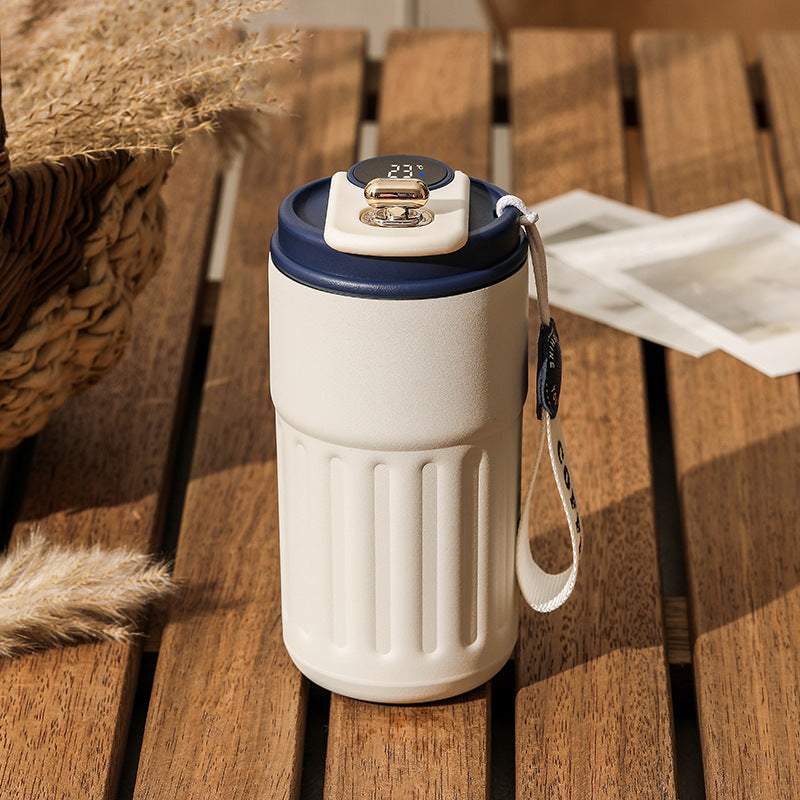 White vacuum insulated coffee mug thermos with digital lid and blue rim, with carry strap