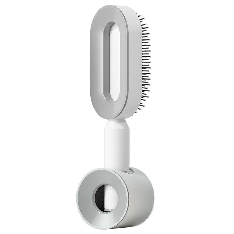 Self-cleaning hair brush with light gray head and white standing handle