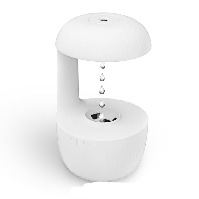 White cool mist humidifier with suspended droplets over the circular top nozzle opening.