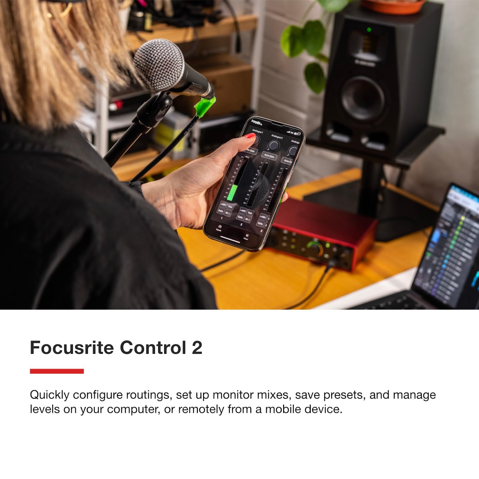 Focusrite Scarlett 18i16 USB audio interface with hand holding smartphone near desk cables