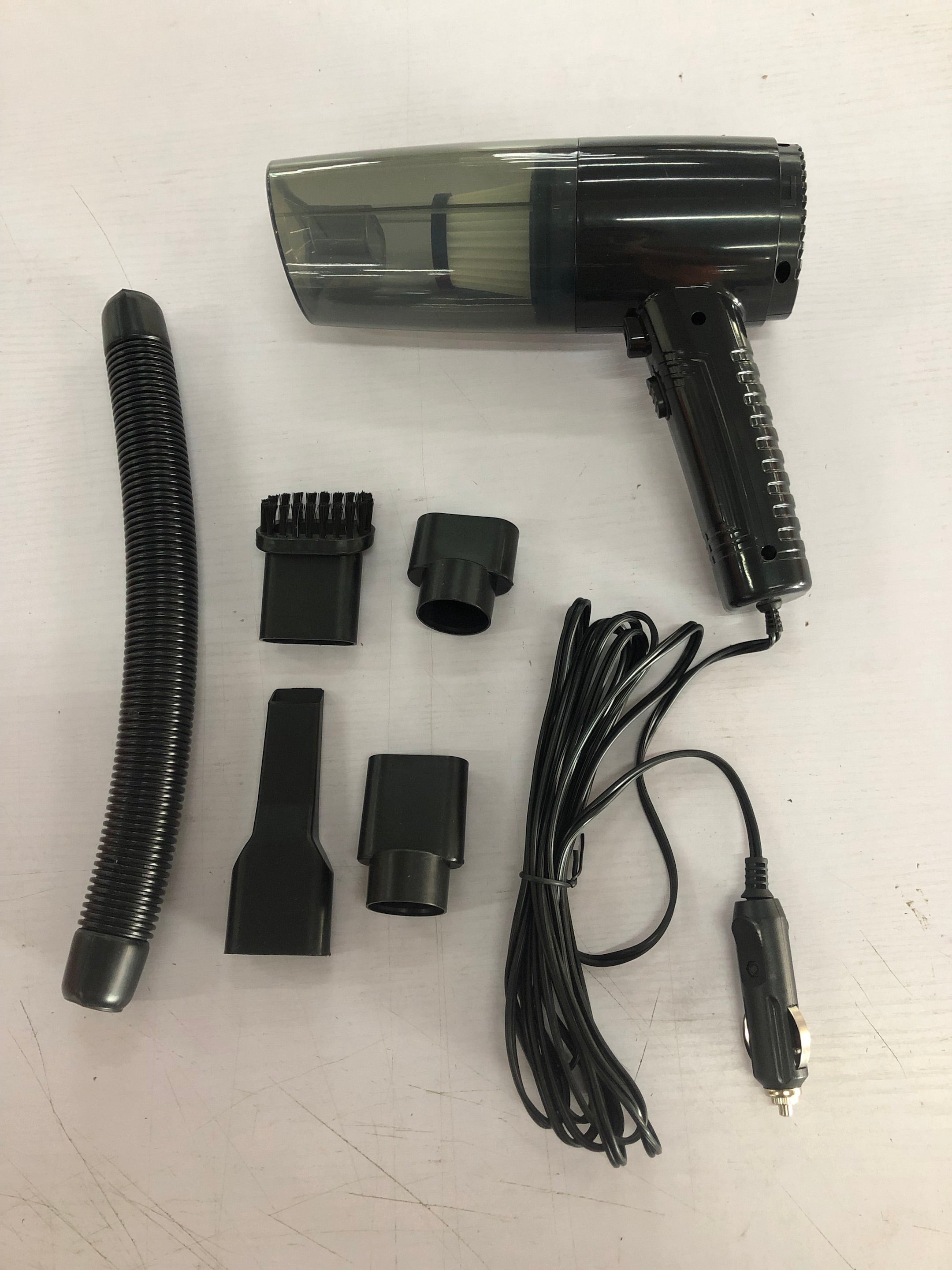 Mini car vacuum cleaner kit laid out: handheld unit, hose, and multiple attachment tools