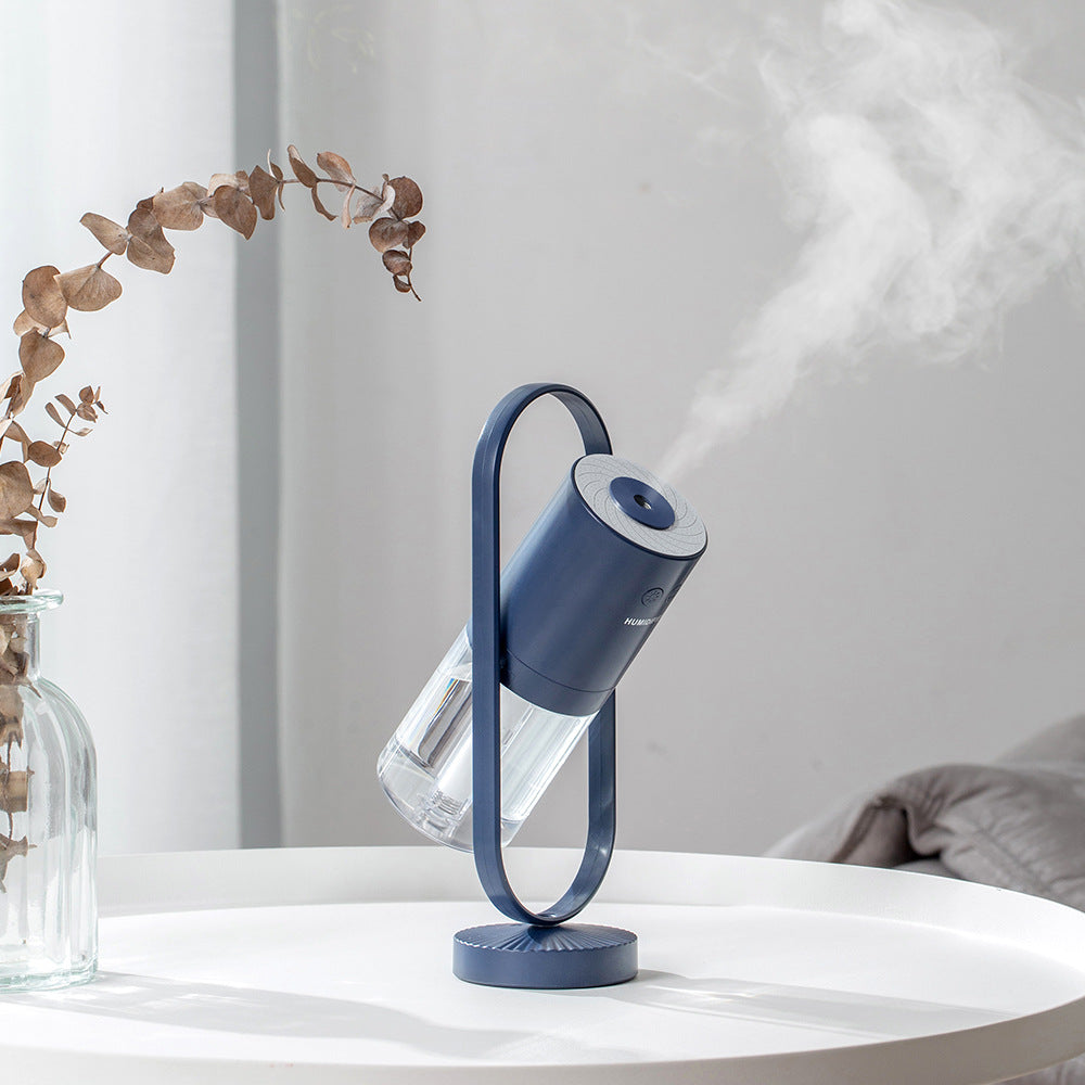 Blue USB air humidifier on countertop with glowing light top and clear mist tube