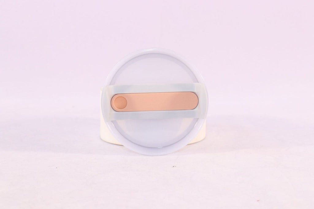 Tumbler lid with straw opening and peach slider, translucent top disc.