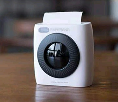 White mini thermal photo printer with dark lens and blue-ring detail