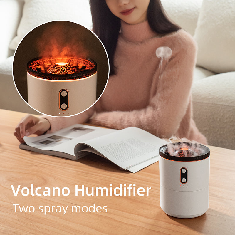 Aroma diffuser humidifier, white cylinder with orange flame-lit top on tabletop