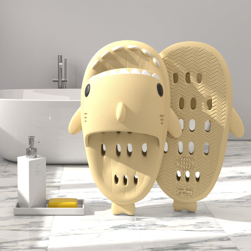 Cream yellow shark-shaped EVA shower slide with drainage holes and textured sole
