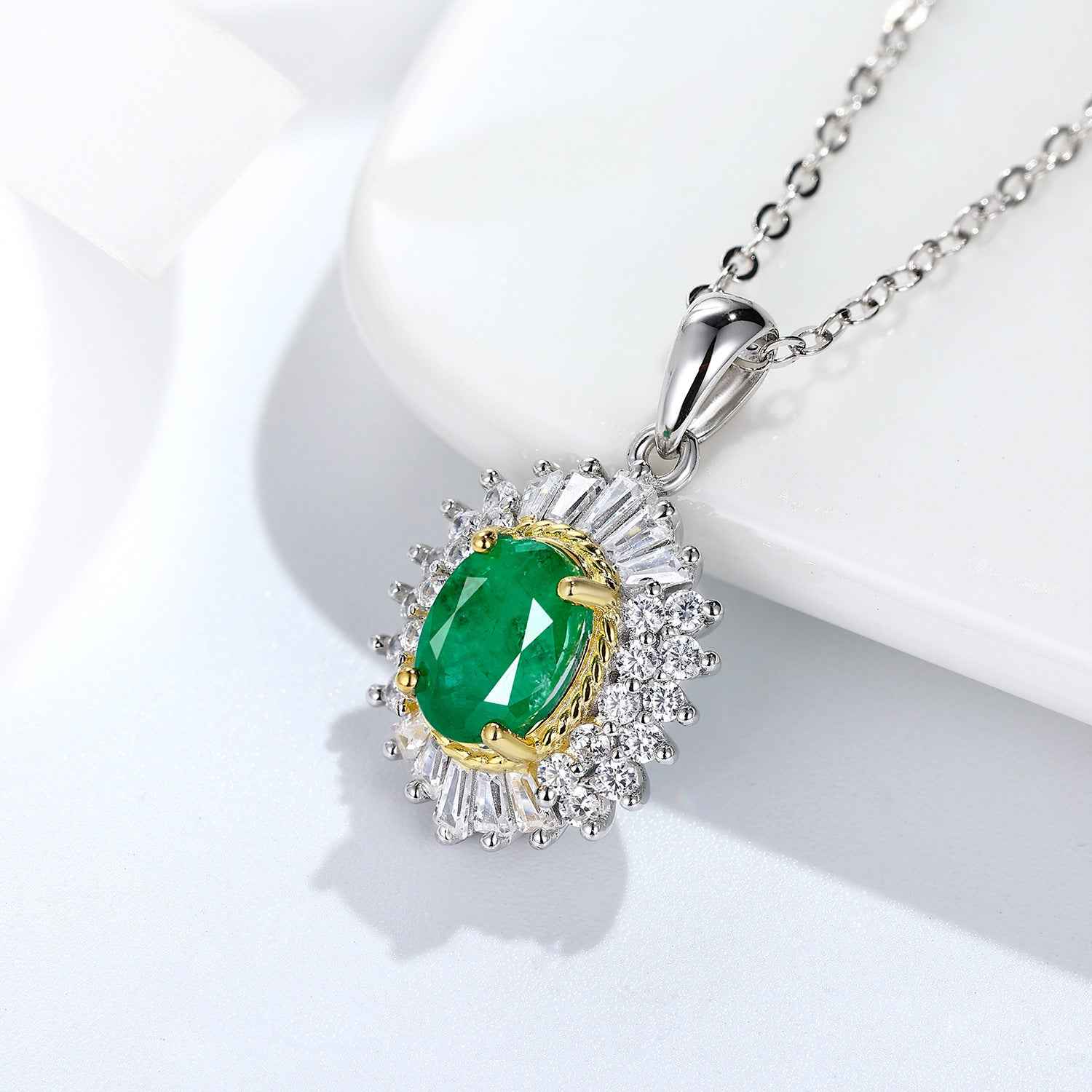 Silver pendant necklace with oval green gemstone and crystal halo, gold rim detail