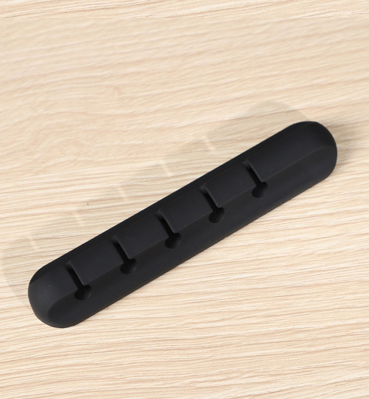 Silicone cable organizer strip with several clip tabs for cables, black