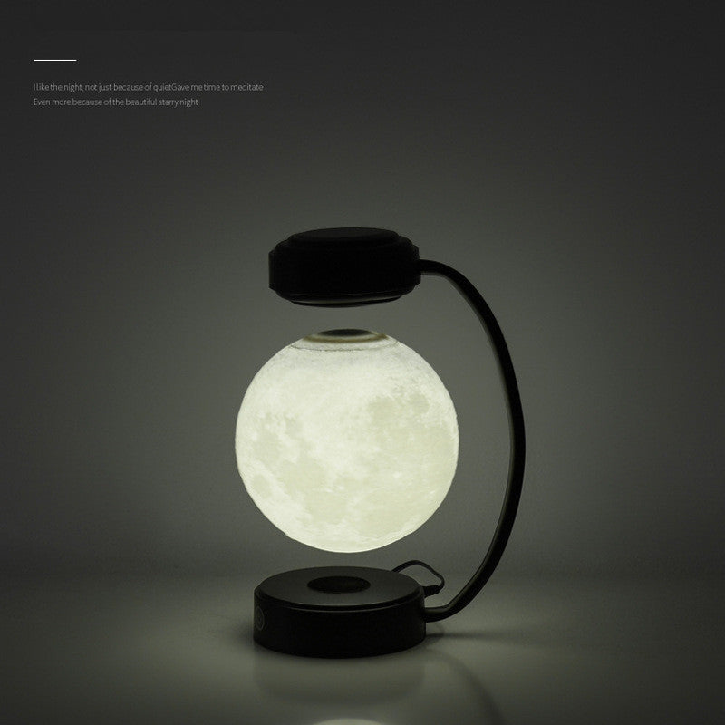Black moon-shaped LED night light with glowing floating globe and curved base stand