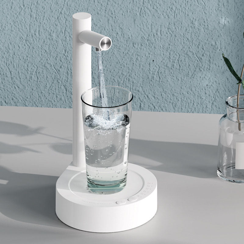 White electric water dispenser pouring water into clear glass cup, countertop base