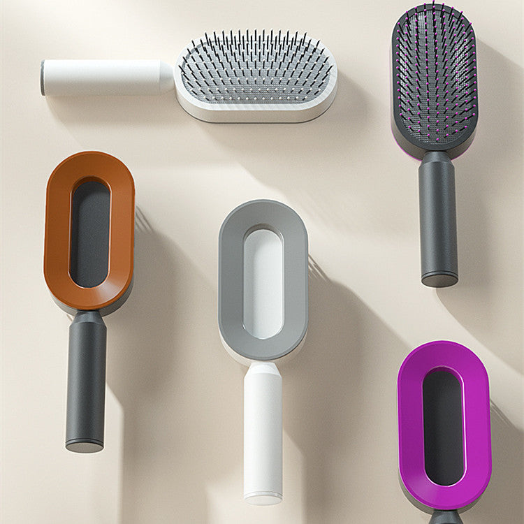 Set of self-cleaning hair brushes with orange, gray, and purple handles and oval heads