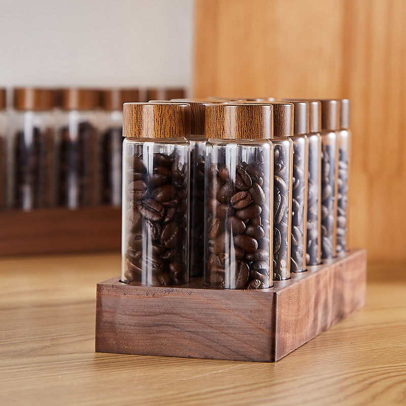 Clear glass bean bottles arranged in a wooden rack with bamboo-style lids
