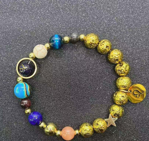 Gold beaded bracelet with blue stones, gold heart charm, and star detail between beads
