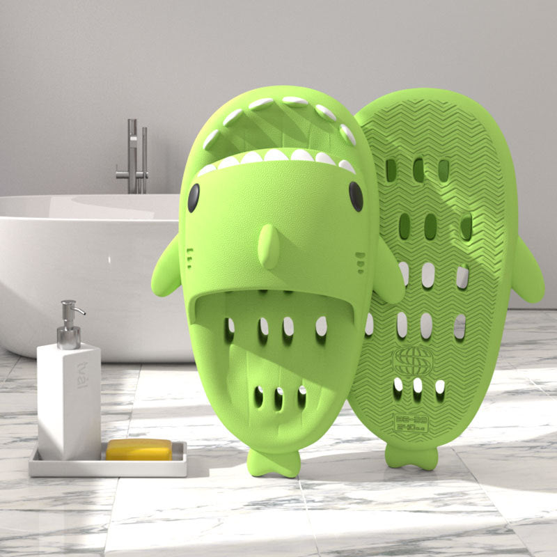 Green shark-shaped EVA shower slide with drainage holes and textured sole