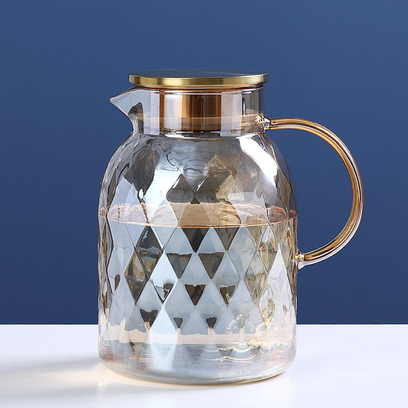 Glass cold water bottle with diamond pattern and gold-tone cap, clear body and side handle