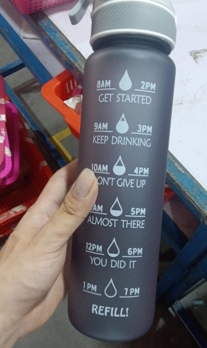 Water bottle with straw cover, dark gradient, printed hydration schedule on front.