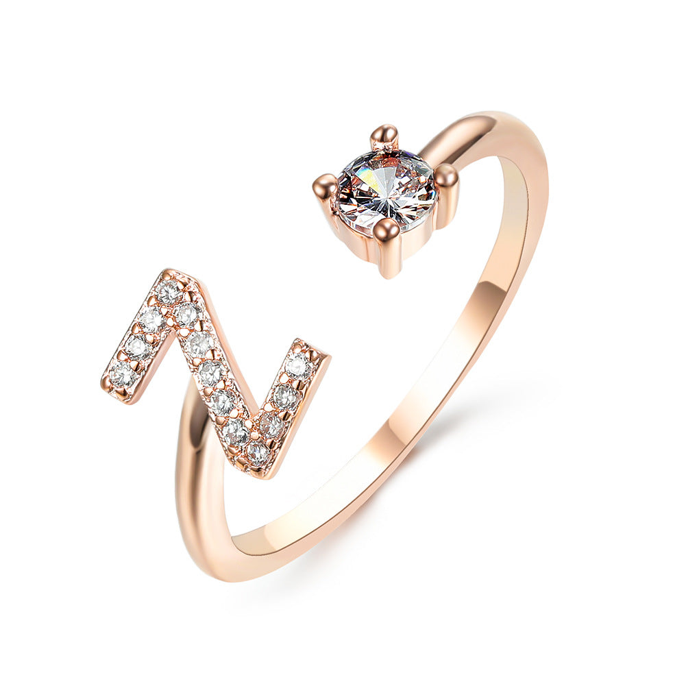 Rose gold adjustable initial ring with N-shaped letter and round center stone.