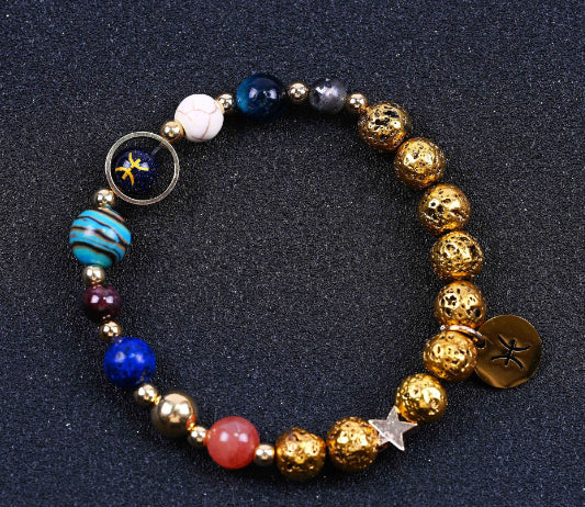 Beaded bracelet with blue and gold beads; round zodiac charm and striped blue globe bead.