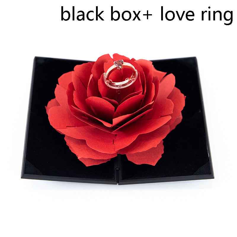 Black ring gift box with red rose flower and heart-shaped ring