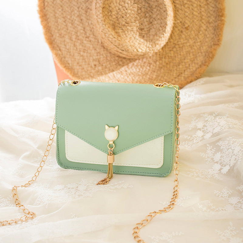 Mint green small messenger bag with cat charm, tassel drop, and gold chain strap