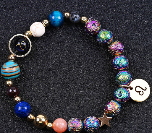 Beaded bracelet with blue and purple speckled beads, striped bead, star charm, zodiac disc charm.
