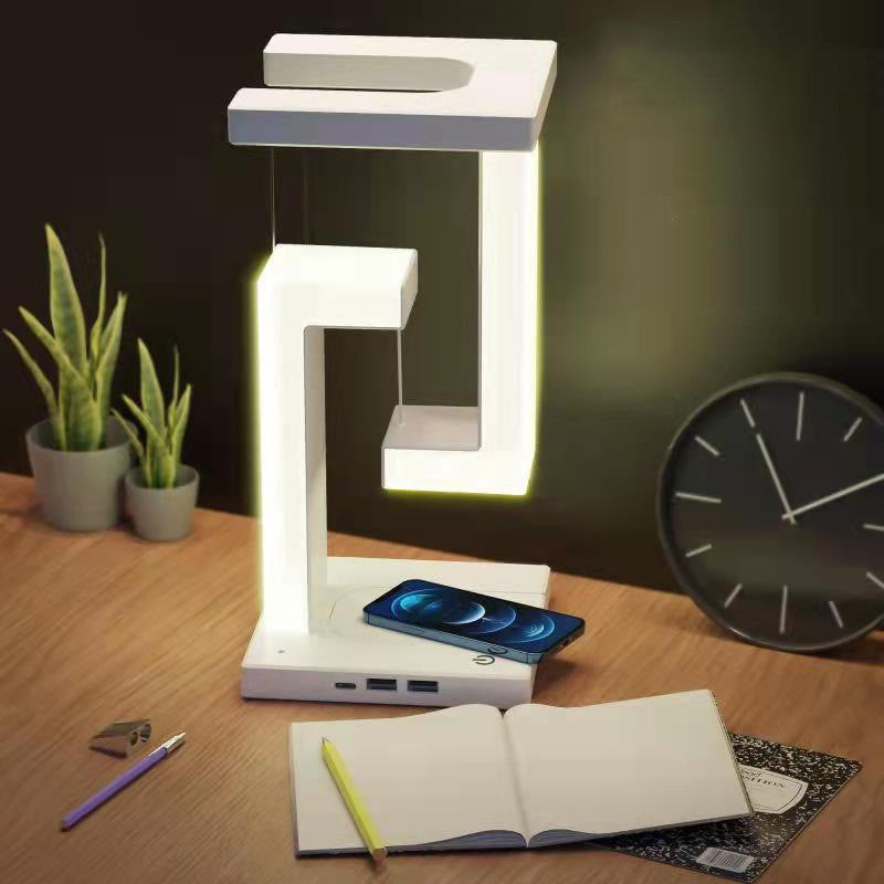 White wireless charging table lamp with glowing frame and built-in phone charging base